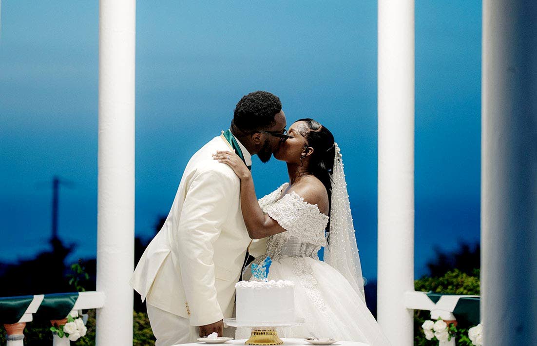 The groom leans in to give his bride a sweet kiss.