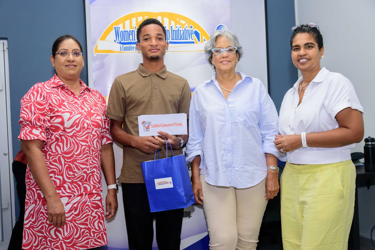 Trevaughn Wilson, a Medical Technology student at Northern Caribbean University, receives a token from Women’s Leadership Initiative representatives (from left) Amanda Beepat, treasurer; Sharon Lake, chair of the Education Committee; and Mellissa McHargh