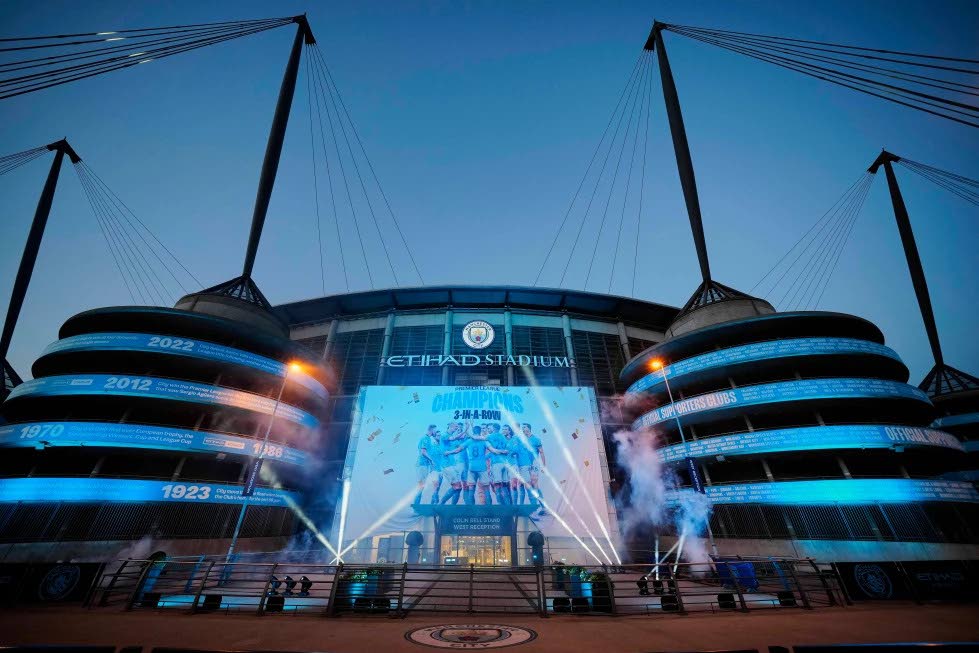 A banner celebrating their title win is illuminated outside Manchester City’s Etihad stadium in Manchester, England, Saturday, May 20, 2023. 
