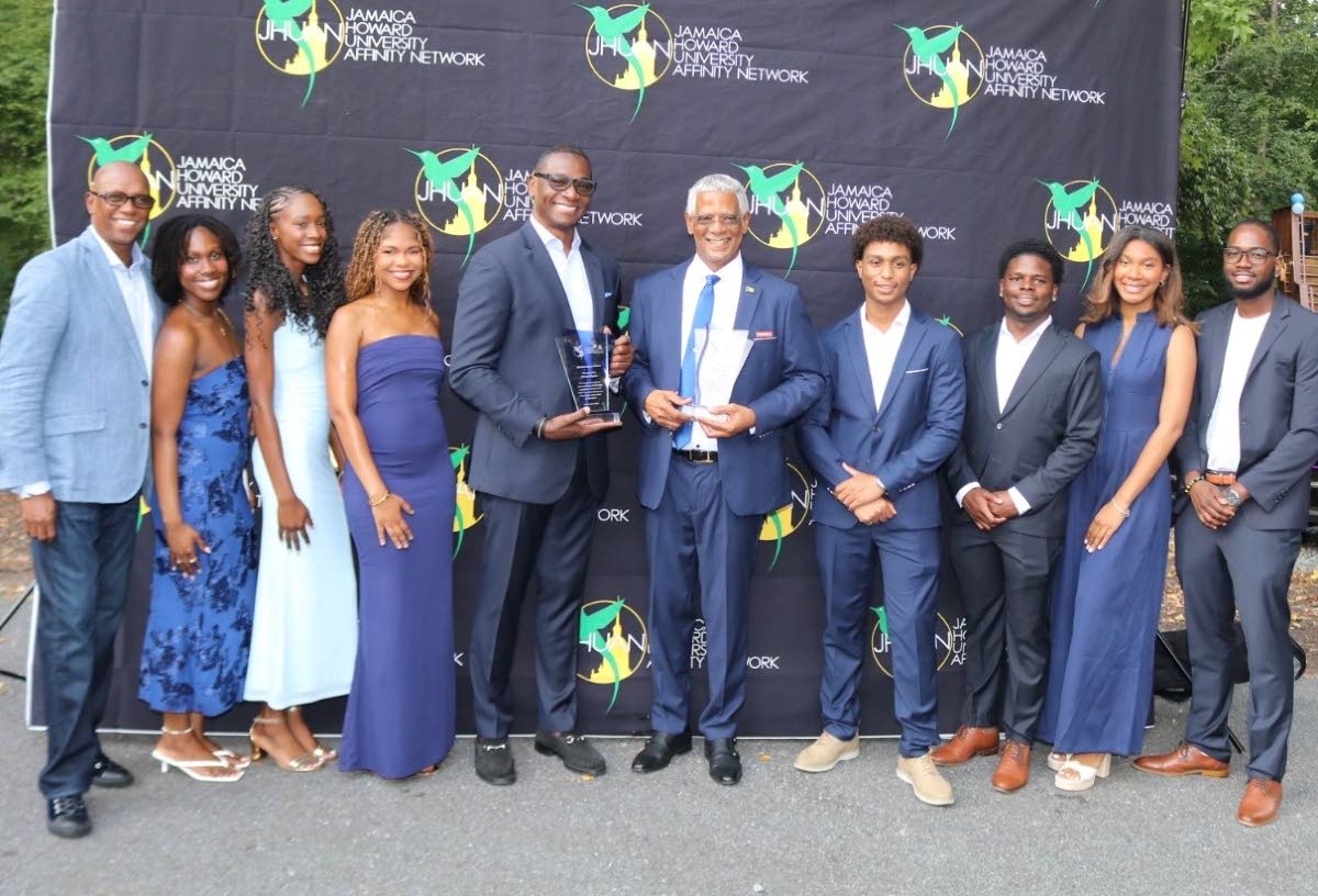 Scholarship recipients gather with 2026 Jamaica Howard University Affinity Network (JHUAN) IMPACT Awardees Trevor Heaven, chairman of FESCO, and Devon Bryan, co-founder of Cyversity, during the seventh annual HUes of Blue fundraising reception at Wellsprin