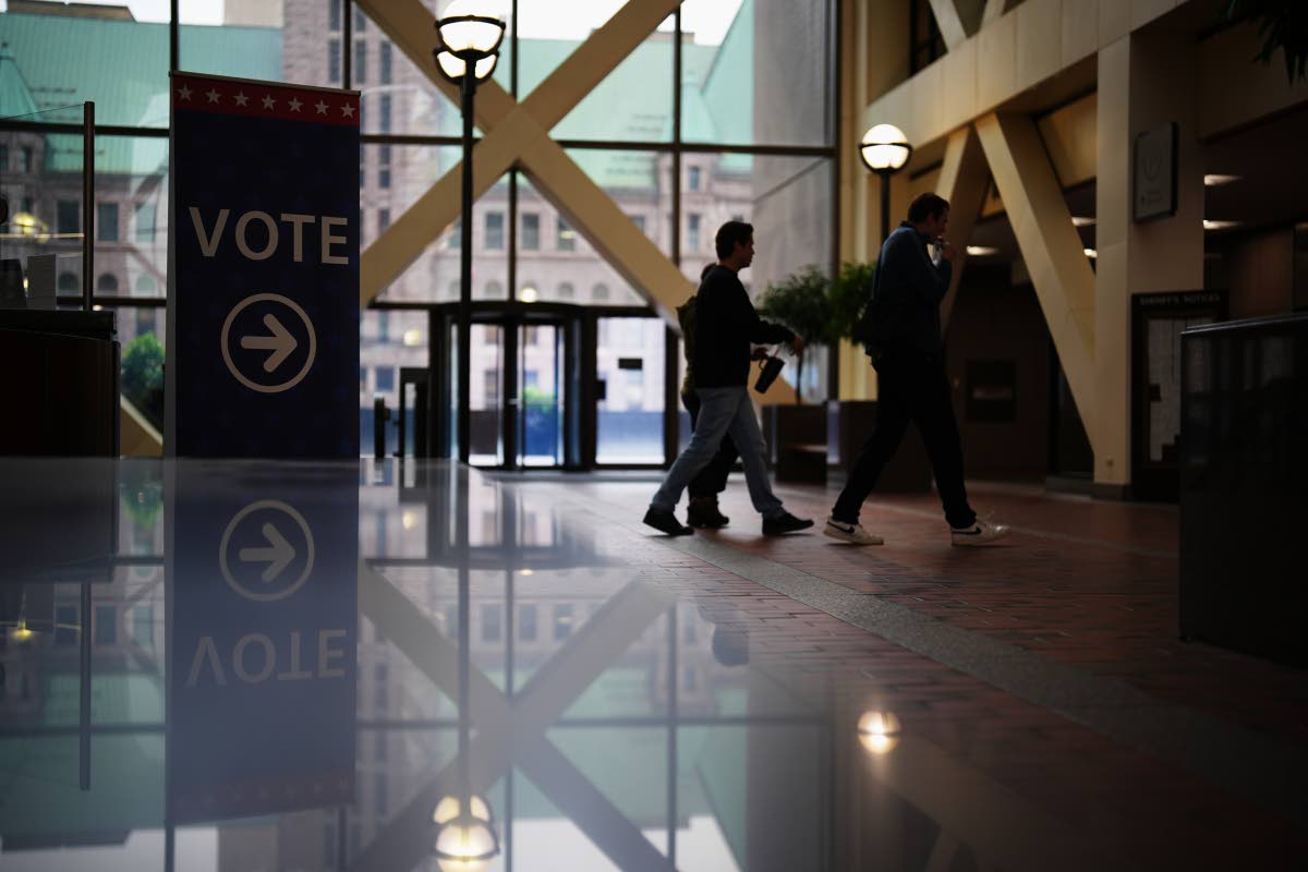 People walk past a sign directing voters on the first day of early voting in Minnesota at the Elections & Voter Services building in Minneapolis, on September 18, 2026. 