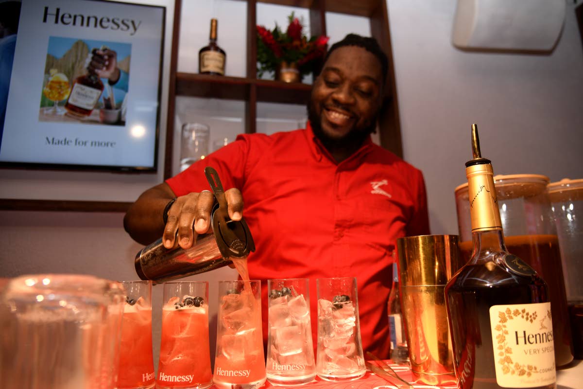 Mixologist Orane Edwards pours a fresh set of Hennessy berry mojitos for guests.