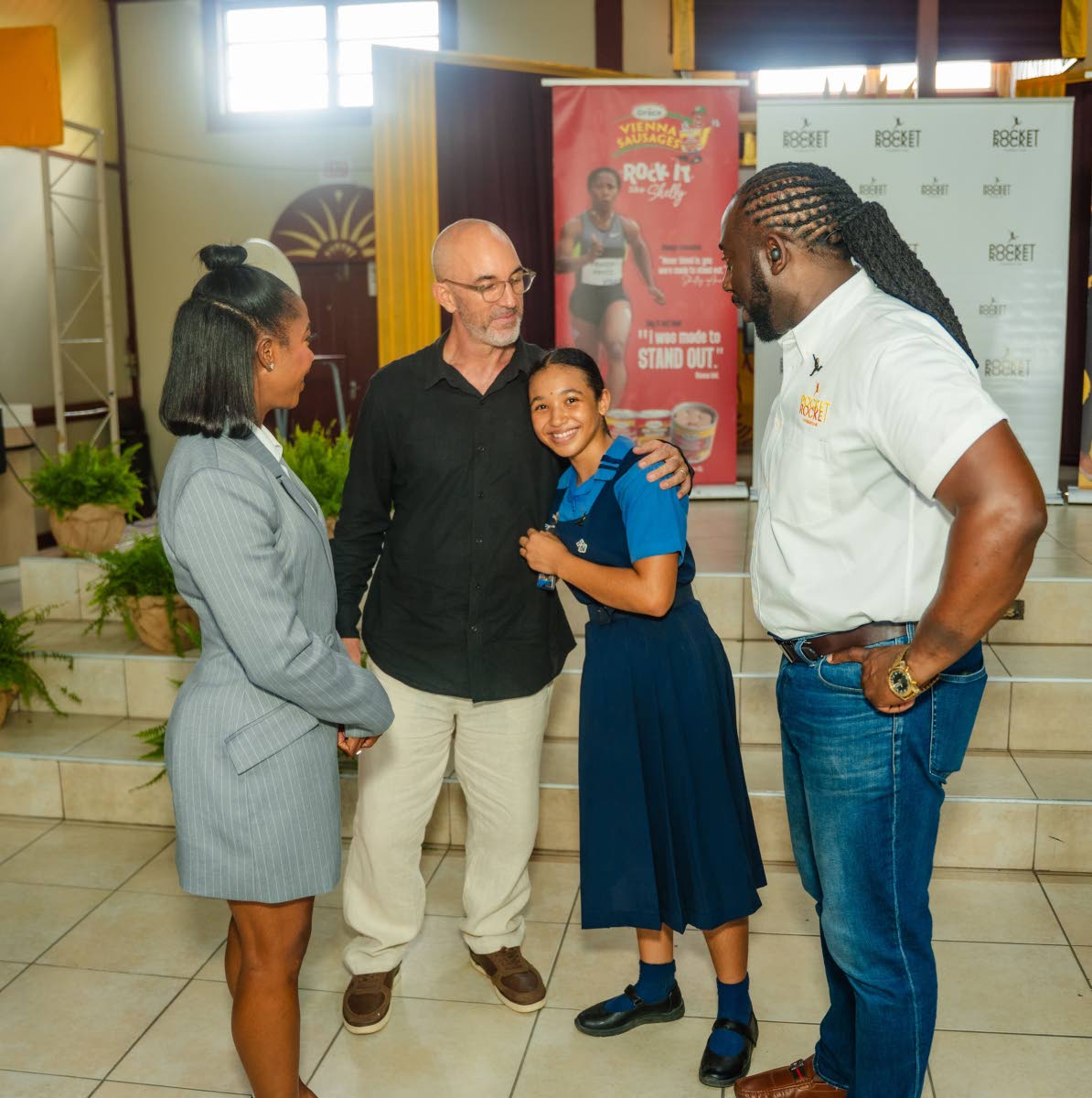 Jazmyne Wilkinson hugs her father, Gregory Wilkinson (second left), as she smiles for the lens. They are joined by Shelly-Ann Fraser-Pryce, founder and chairwoman of the Pocket Rocket Foundation, and Dr Jermaine McCalpin, executive director of the Pocket R