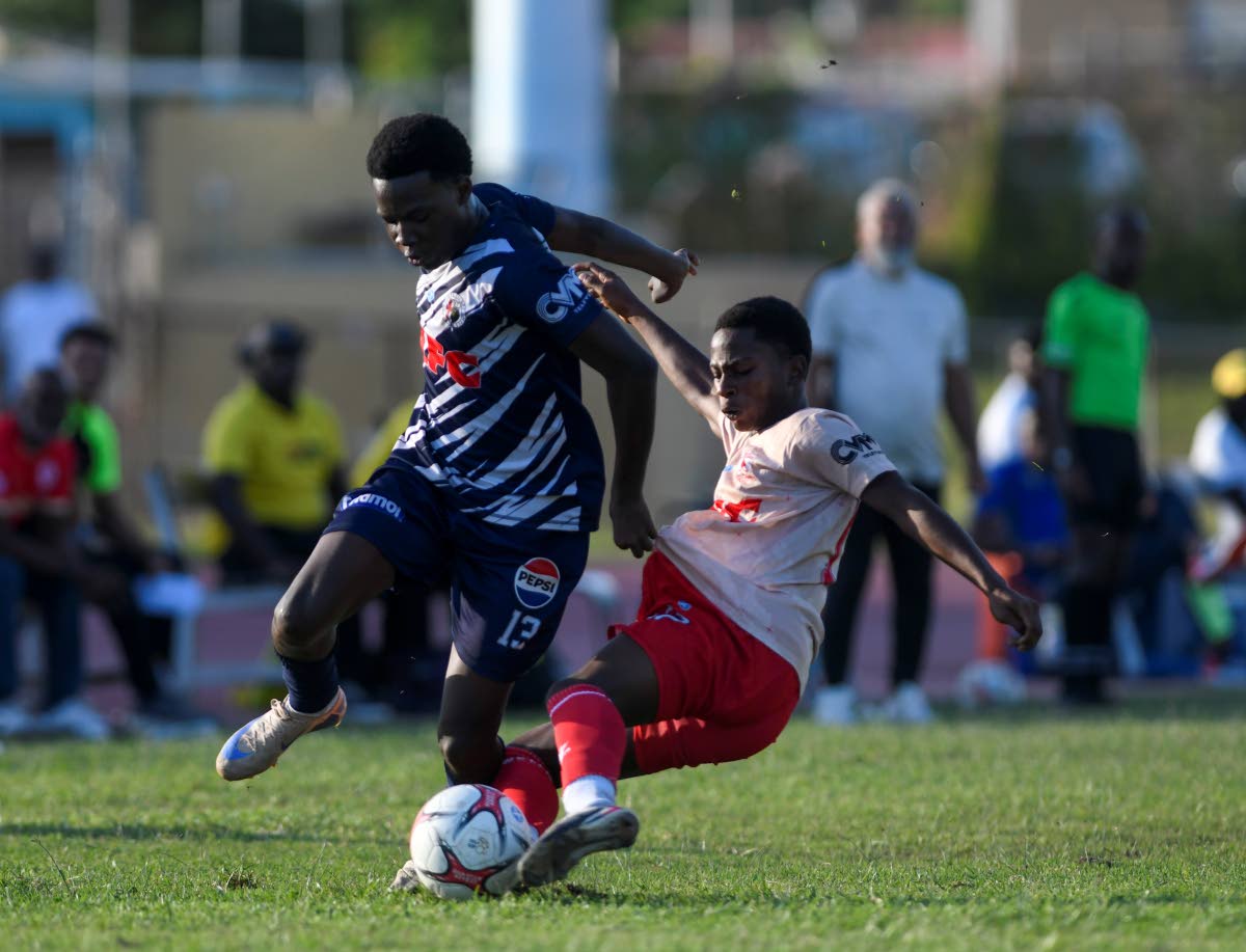
Jamaica College’s Gerveir Grant tries to evade a challenge from Mona High’s Shaquille Lindo during their Walker Cup semi-final at Stadium East yesterday. JC won 4-3 on penalties after a 3-3 regulation time draw. 