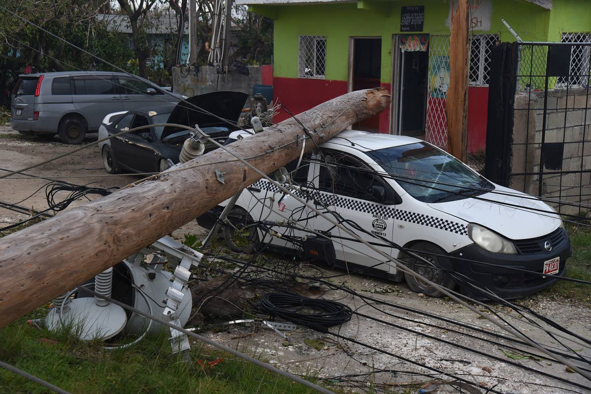 A utility pole broke and fell on a parked car in Salt Marsh, Trelawny, during the passage of Hurricane Melissa last October.