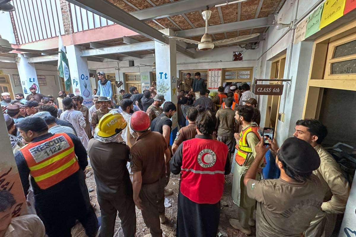 Rescue workers and volunteers take part in the rescue operation at the site of a roof collapse at a private school, in Peshawar, Pakistan, Thursday, Oct. 15, 2026. (AP Photo/Maaz Awan)