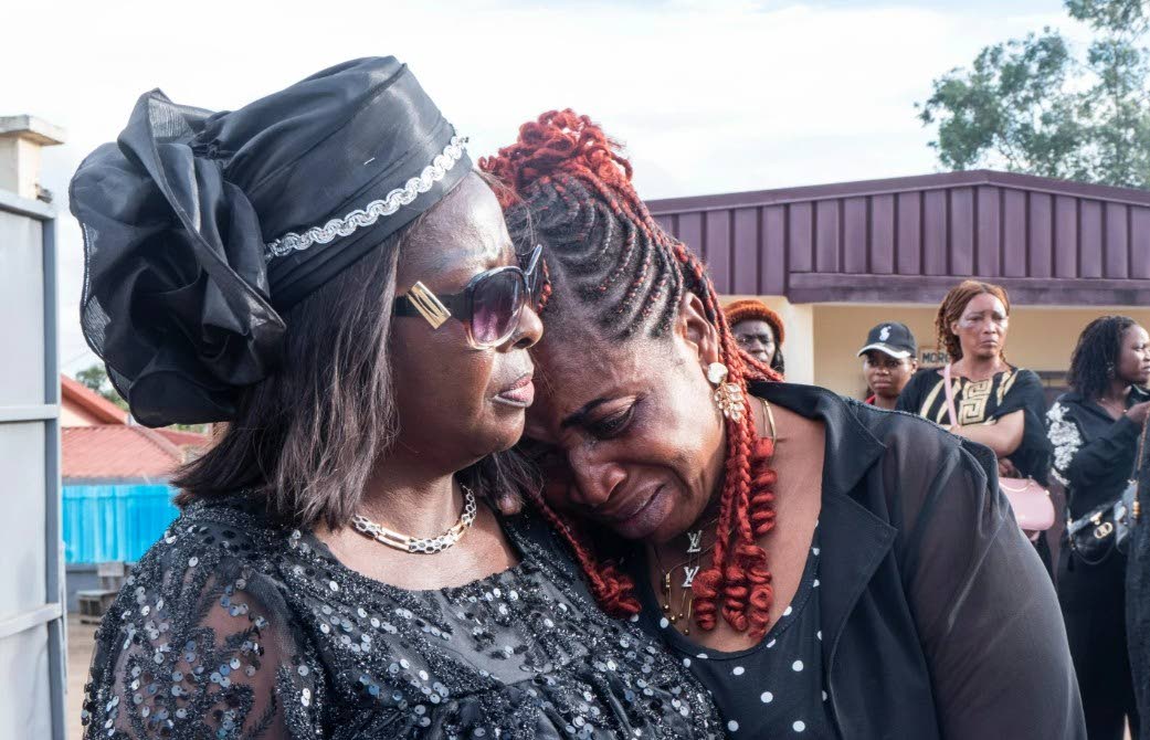 Geraldine Achiah's sister, right, is comforted as she grieves outside a mortuary chapel in Yaoundé, Cameroon, Friday, September 18, 2026.