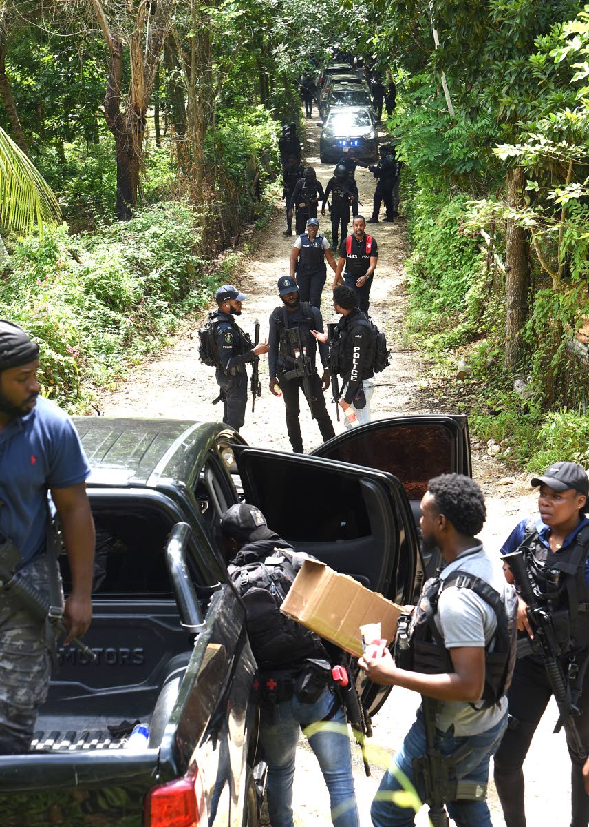 Members of the Jamaica Constabulary Force (JCF) converge at a scene in the Five Miles area of Sligoville in St Catherine, where three cops were shot, one fatally, and three gunmen killed during an operation on Friday.