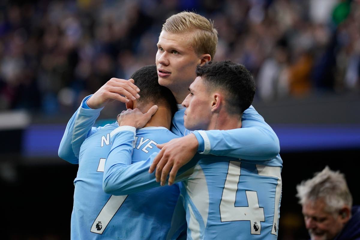 Manchester City's Erling Haaland celebrates with his teammates Phil Foden and Iliman Ndiaye after scoring his side's third goal during the English Premier League soccer match between Manchester City and Ipswich Town, in Manchester, England, Saturday, Oct.1