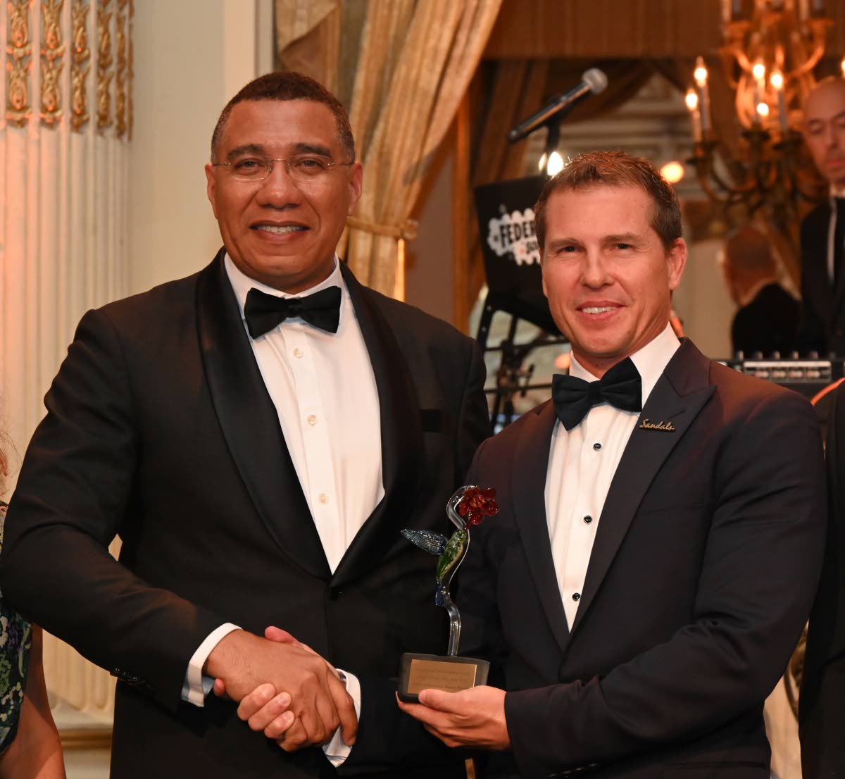 Prime Minister Dr Andrew Holness (left) presents Adam Stewart, executive chairman of Sandals Resorts International, with the Leadership Award at the American Friends of Jamaica’s Hummingbird Gala last Friday.
