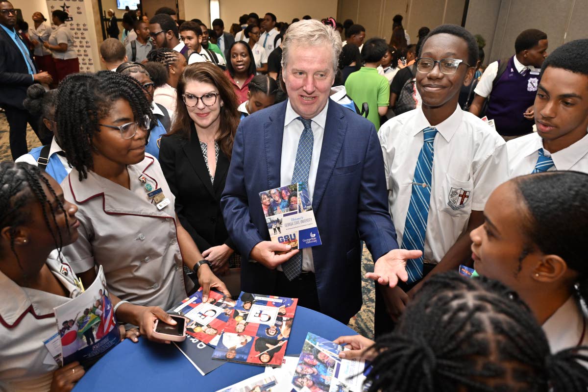 Scott Renner (centre), charge d’affaires at the United States (US) Embassy in Kingston; and Erin Mai Jarrett (third left), public affairs attaché at the embassy, speak with students at the EducationUSA College Fair held yesterday at The Jamaica Pegasus 