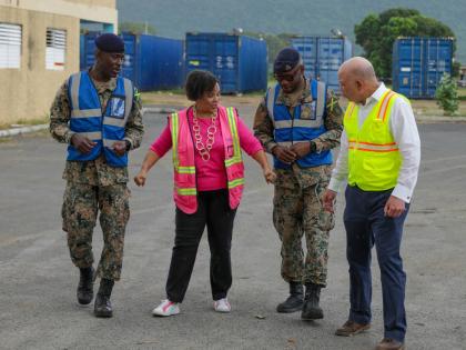 Seaboard Jamaica’s CEO, Corah Ann Robertson-Sylvester (second left), briefs (from left) Colonel Anthony Gregory, Major Dwayne Trowers, and Pan Jamaica Group Vice-Chairman and CEO Jeffrey Hall, on the coordinated efforts behind the donation of eight 40-fo