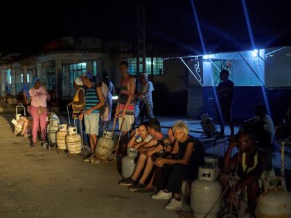 People wait to refill their cooking gas canisters in Alamar, Havana province, Cuba, late on Saturday, May 31, 2025. 