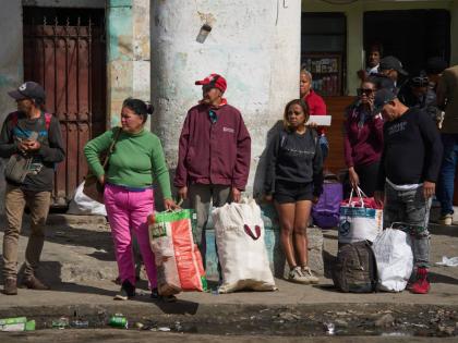 People wait to board transportation in Havana, Cuba.