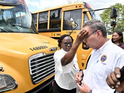 Bishop Christine Gooden-Benguche, president of the Jamaica Council of Churches, blessing Transport Minister Dary Vaz at a handover ceremony for the buses under the National Rural School Bus Programme last August.