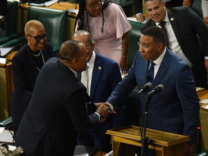 Prime Minister Dr Andrew Holness (right) is congratulated by Government members of the House of Representatives after making his contribution to the 2026-2027 Budget Debate at Gordon House in downtown Kingston yesterday. 