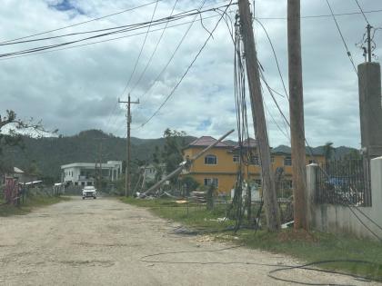 Cables hang from a utility pole and trail along the roadside in Carawina, Westmoreland.