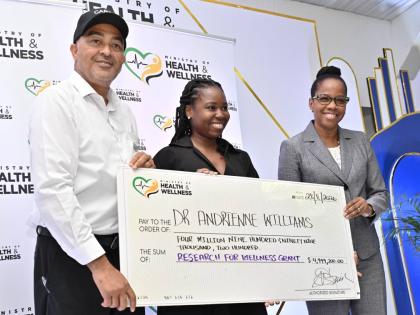 Dr Christopher Tufton, minister of health and wellness; and Dr Karen Webster Kerr (right), national epidemiologist in the Ministry of Health and Wellness, present a grant to Dr Andrienne Williams for wellness research at the Ministry of Health and Wellness