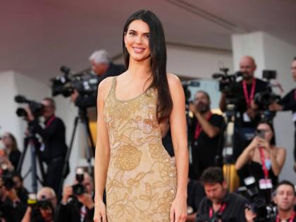 Emporio Armani global fragrance ambassador Kendall Jenner goes for gold in a vintage 1995 Giorgio Armani gown.
