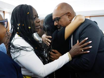 Friends and family members of rapper Tupac Shakur, including his sister, Sekyiwa Shakur (second left), line up to hug Chief Deputy District Attorney Binu Palal (right), after a jury found Duane Davis guilty of first-degree murder in his trial related to th