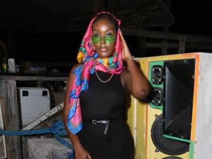 Make-up artist and entrepreneur Davene Jonas stylishly tops off her all-black look with a colourful headscarf and neon shades.