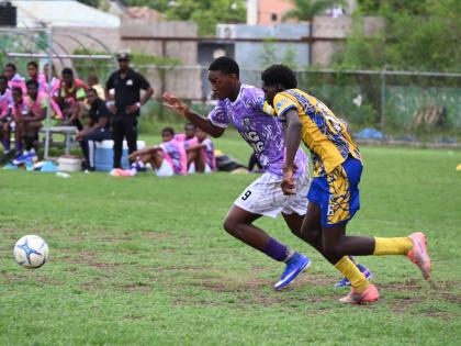 Irwin High’s Nathaniel Foster (left) and Cambridge High’s Dushaun Thomas go in chase of the ball during their ISSA daCosta Cup preliminary round game at Jarrett Park yesterday.